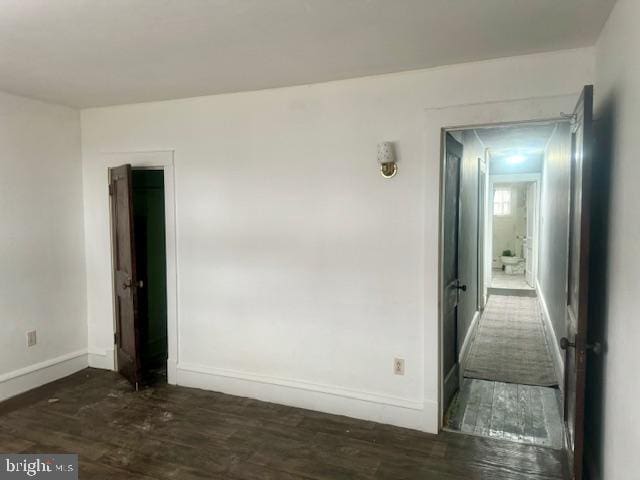 unfurnished room with dark wood-type flooring