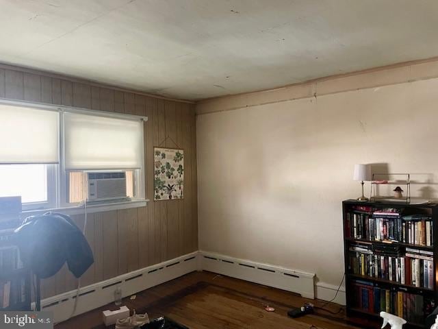 miscellaneous room with dark hardwood / wood-style flooring, baseboard heating, cooling unit, and wooden walls