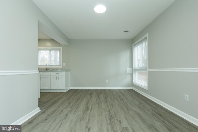 unfurnished living room featuring light hardwood / wood-style flooring and sink