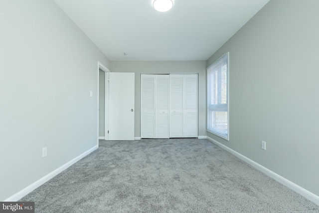 unfurnished bedroom with light carpet and a closet