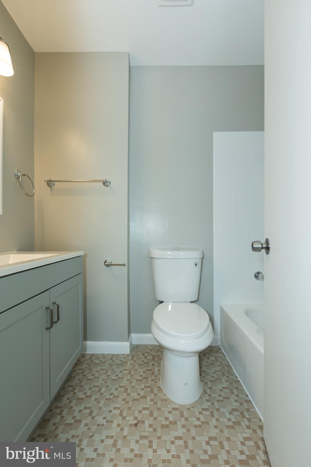 bathroom featuring vanity, toilet, and a tub