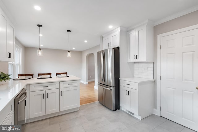 kitchen with decorative backsplash, light tile patterned floors, decorative light fixtures, white cabinetry, and stainless steel appliances