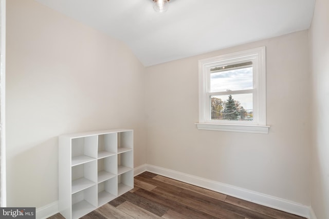 spare room featuring hardwood / wood-style flooring and vaulted ceiling