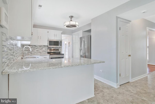 kitchen with white cabinetry, appliances with stainless steel finishes, sink, and kitchen peninsula