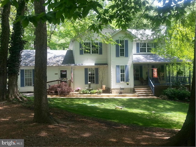 back of house with covered porch and a lawn