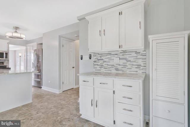 kitchen with light stone counters, appliances with stainless steel finishes, decorative backsplash, and white cabinets