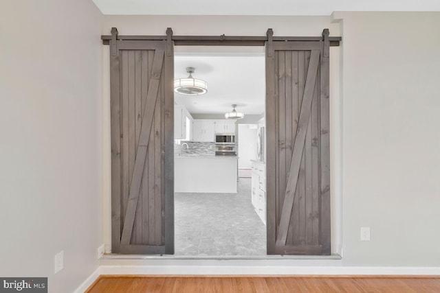 interior space with a barn door and light wood-type flooring