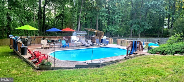 view of swimming pool featuring an outdoor structure, an outdoor bar, and a lawn