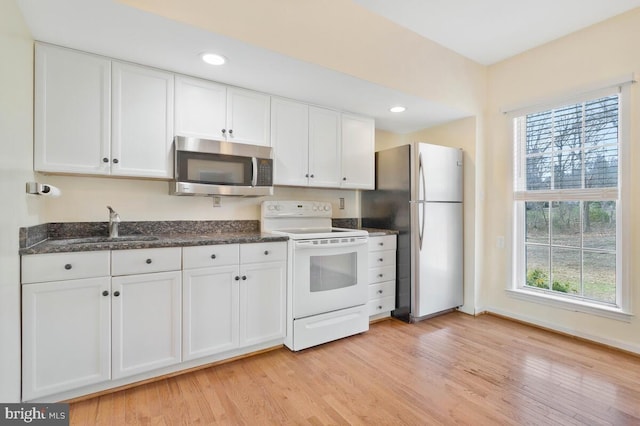 kitchen with sink, plenty of natural light, stainless steel appliances, and white cabinets