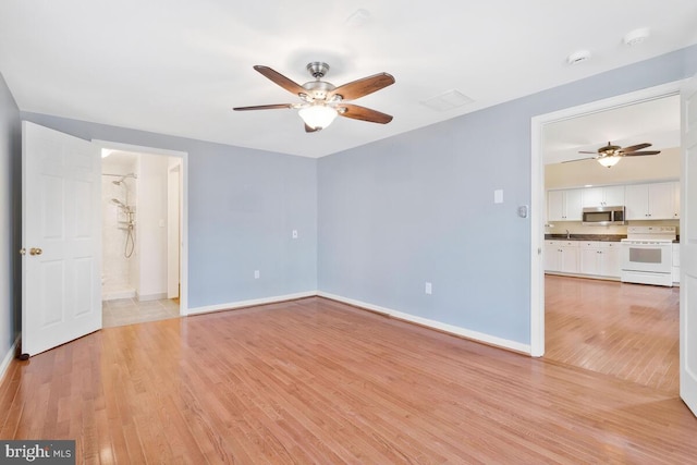 spare room featuring ceiling fan and light hardwood / wood-style flooring