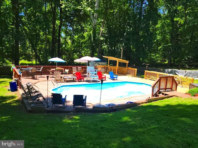 view of pool featuring a wooden deck and a lawn