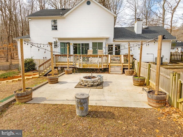 back of property featuring a fire pit, a patio area, and a deck