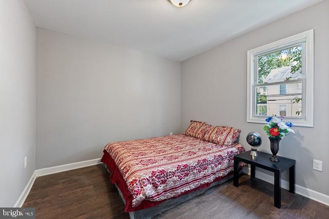 bedroom with dark wood-type flooring