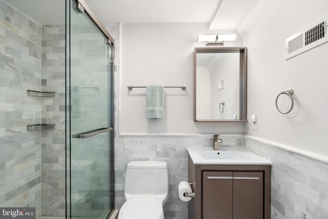 bathroom featuring vanity, toilet, tile walls, and an enclosed shower