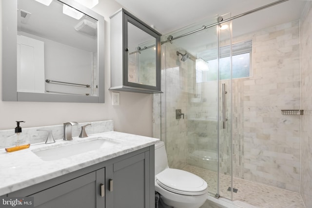 bathroom featuring vanity, toilet, and walk in shower