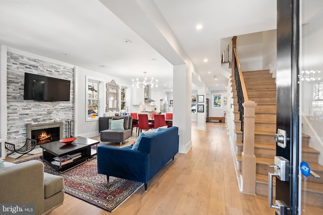 living room with plenty of natural light, a tile fireplace, and light hardwood / wood-style flooring