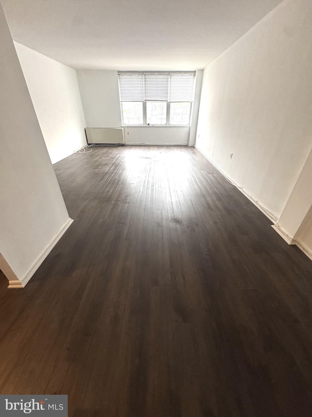 unfurnished room featuring dark wood-type flooring