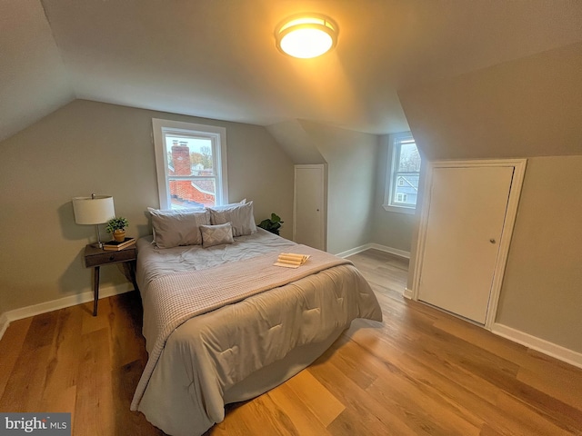 bedroom featuring vaulted ceiling and light wood-type flooring