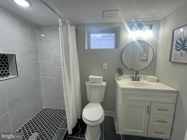 bathroom featuring tile patterned flooring, vanity, toilet, and walk in shower