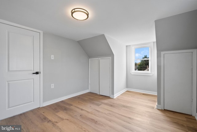 bonus room featuring light hardwood / wood-style floors and vaulted ceiling