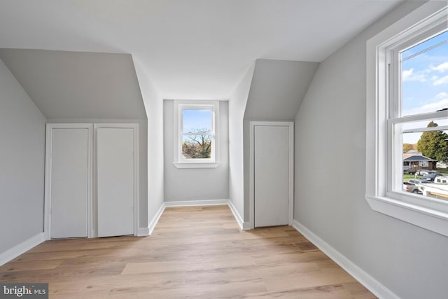 bonus room with light hardwood / wood-style floors and vaulted ceiling