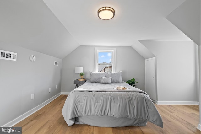 bedroom with light hardwood / wood-style flooring and lofted ceiling