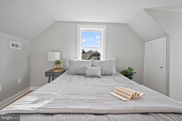 bedroom featuring wood-type flooring and vaulted ceiling