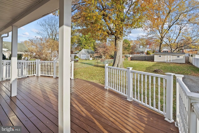 deck featuring a storage unit and a lawn