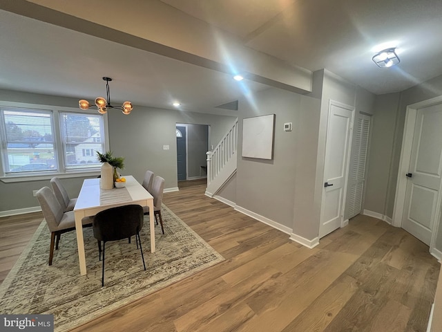 dining space featuring light hardwood / wood-style floors and an inviting chandelier