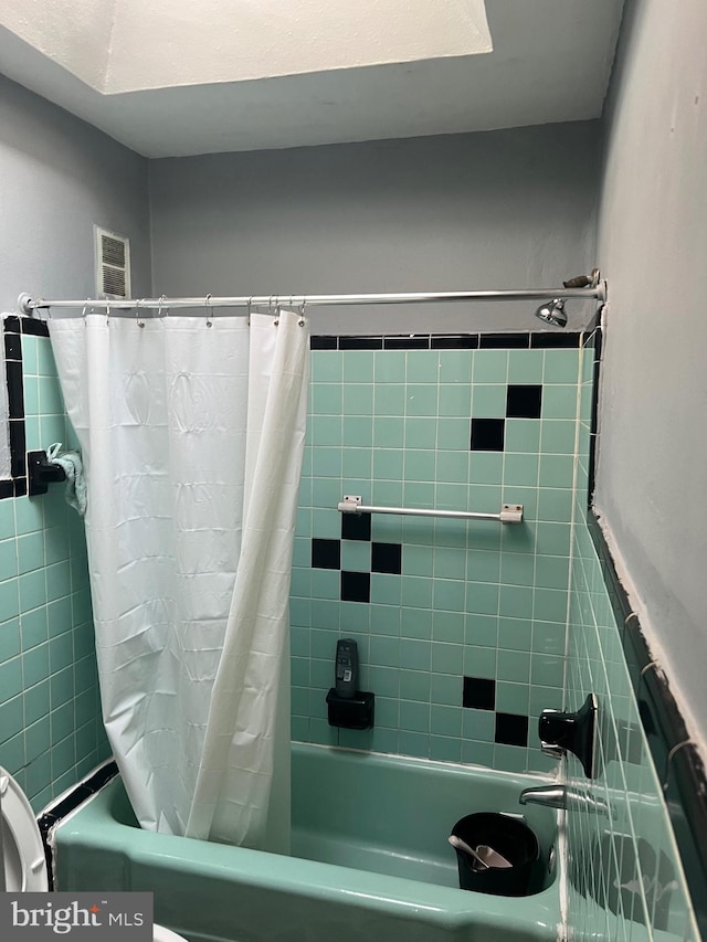 bathroom featuring shower / tub combo with curtain