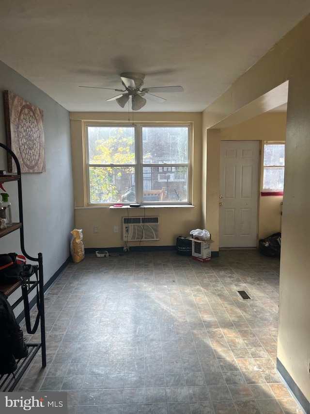 interior space featuring an AC wall unit and ceiling fan