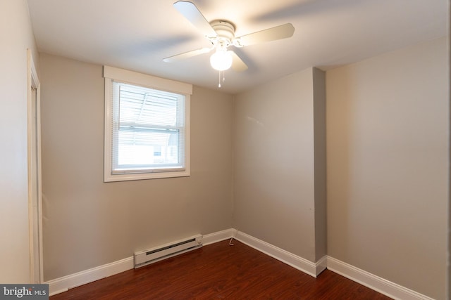 spare room featuring baseboard heating, ceiling fan, and dark wood-type flooring