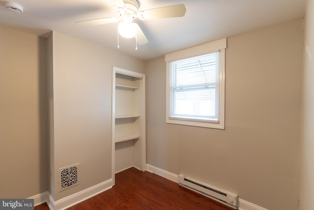 unfurnished bedroom with a closet, dark hardwood / wood-style floors, baseboard heating, and ceiling fan