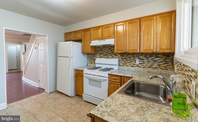 kitchen with decorative backsplash, white appliances, light tile patterned flooring, and sink