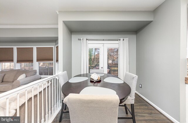 dining space featuring dark hardwood / wood-style floors, crown molding, and french doors