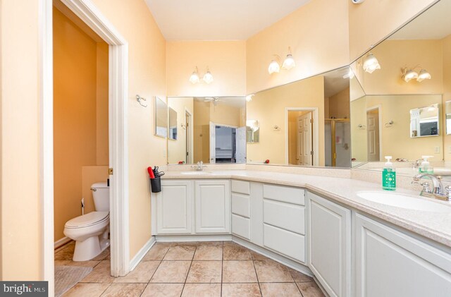 bathroom with tile patterned floors, vanity, toilet, and a shower with shower door