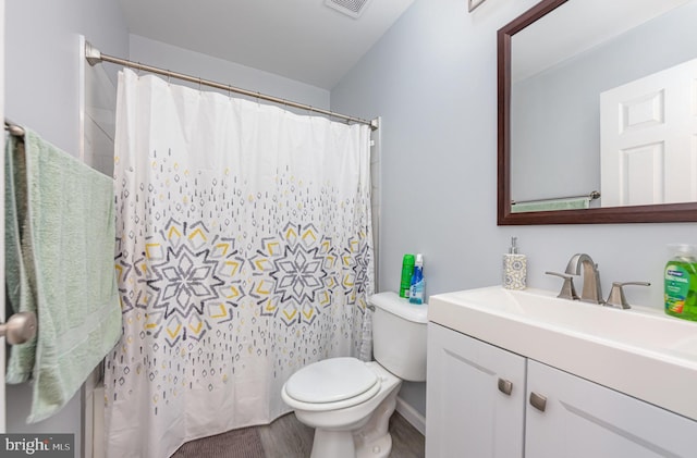 bathroom with toilet, vanity, and hardwood / wood-style flooring