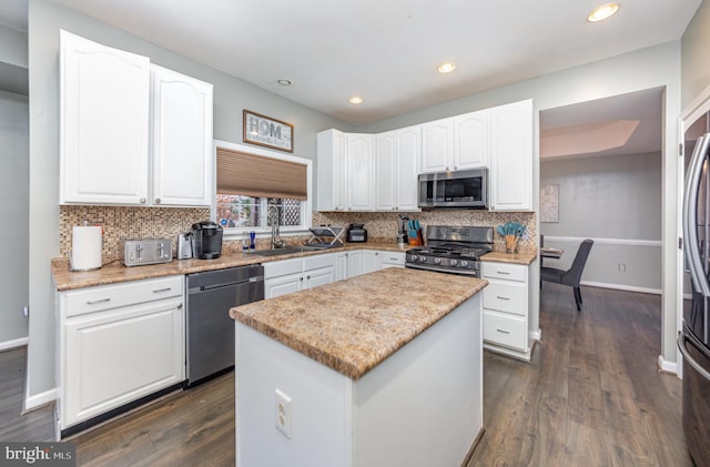 kitchen featuring a kitchen island, white cabinetry, sink, and appliances with stainless steel finishes