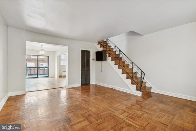 unfurnished room featuring a notable chandelier, parquet flooring, and radiator