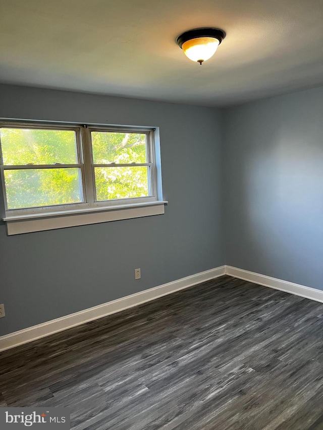 unfurnished room featuring dark wood-type flooring