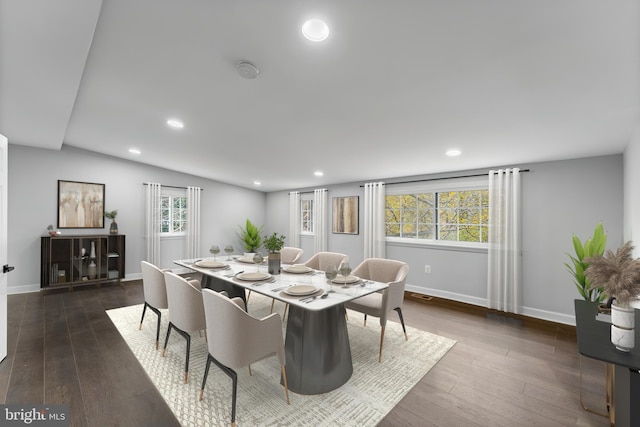 dining area with plenty of natural light, dark wood-type flooring, and lofted ceiling