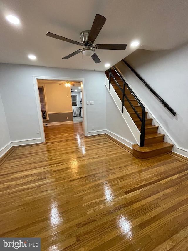 unfurnished living room featuring hardwood / wood-style flooring and ceiling fan