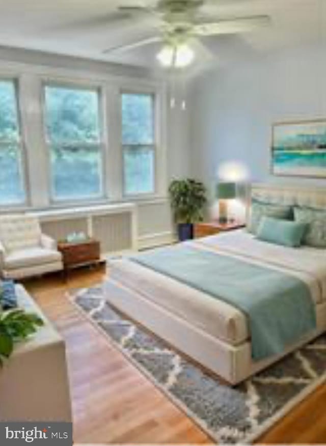 bedroom with ceiling fan and hardwood / wood-style flooring