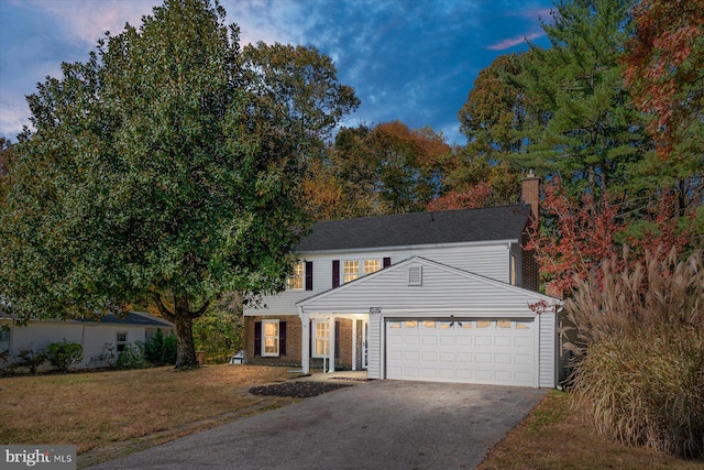 view of front of property featuring a lawn and a garage