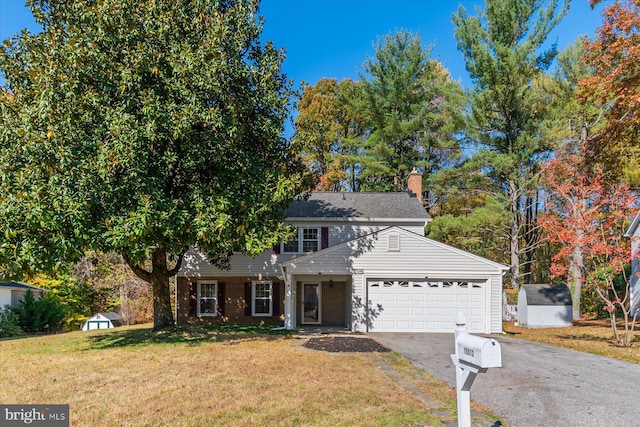 front of property featuring a front yard, a shed, and a garage