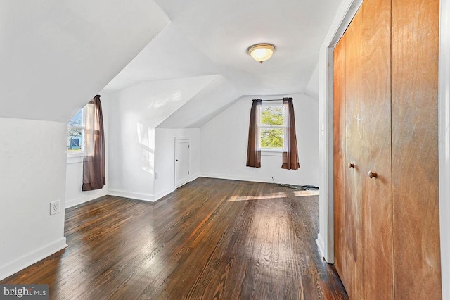 additional living space with dark hardwood / wood-style flooring and vaulted ceiling