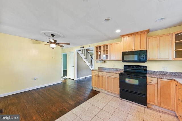 kitchen with light brown cabinetry, ceiling fan, light hardwood / wood-style flooring, and black appliances