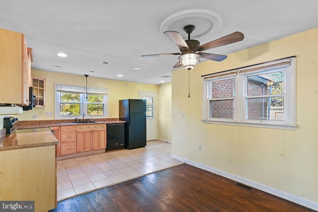 kitchen with light wood-type flooring, ceiling fan, sink, black appliances, and decorative light fixtures