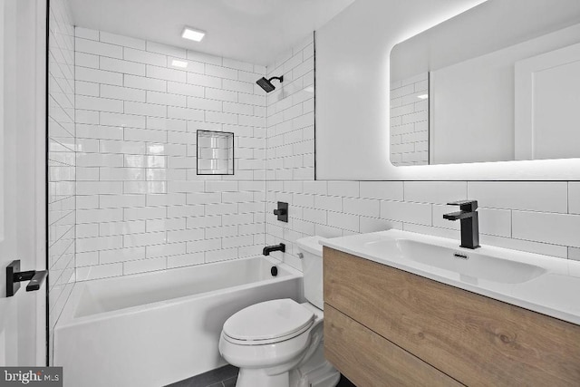 full bathroom with vanity, decorative backsplash, tiled shower / bath combo, toilet, and tile walls