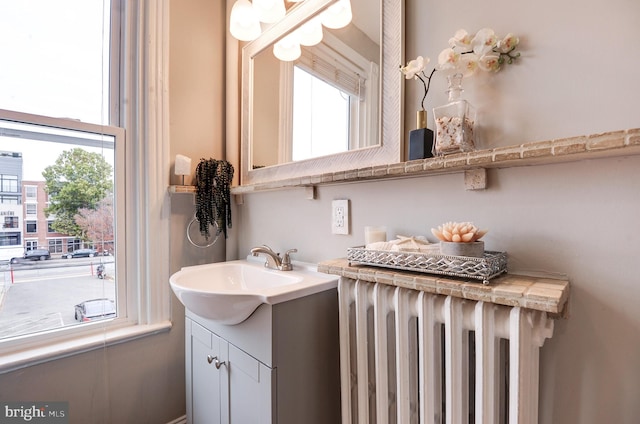 bathroom featuring radiator, vanity, and a healthy amount of sunlight